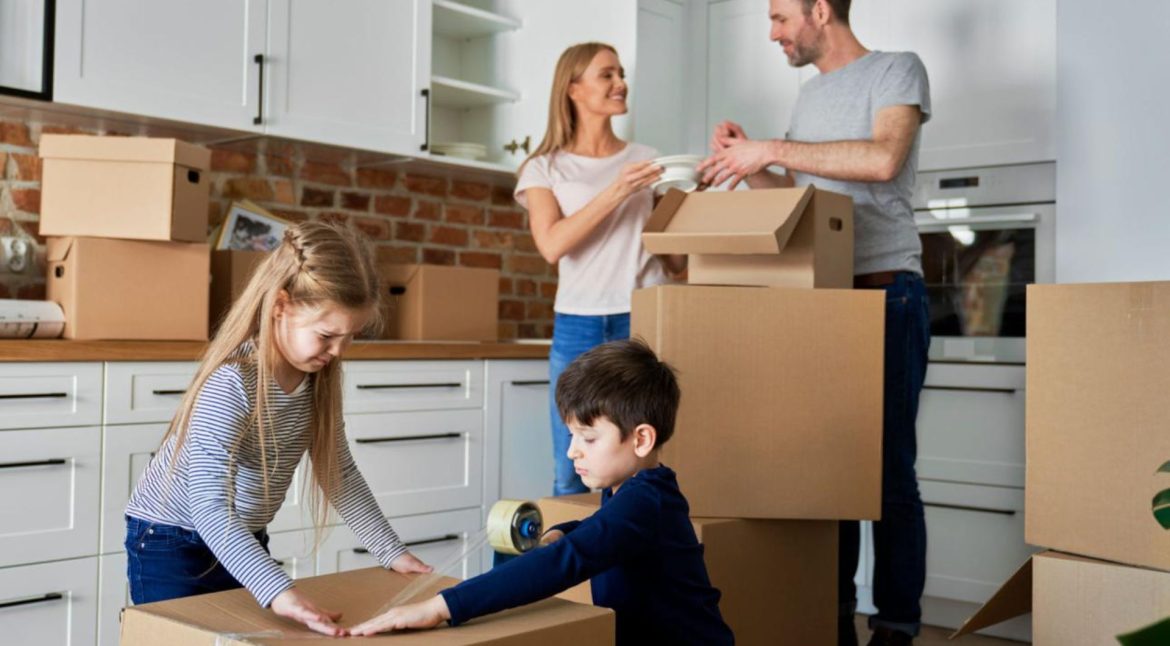 Family packing moving boxes while preparing for a home relocation