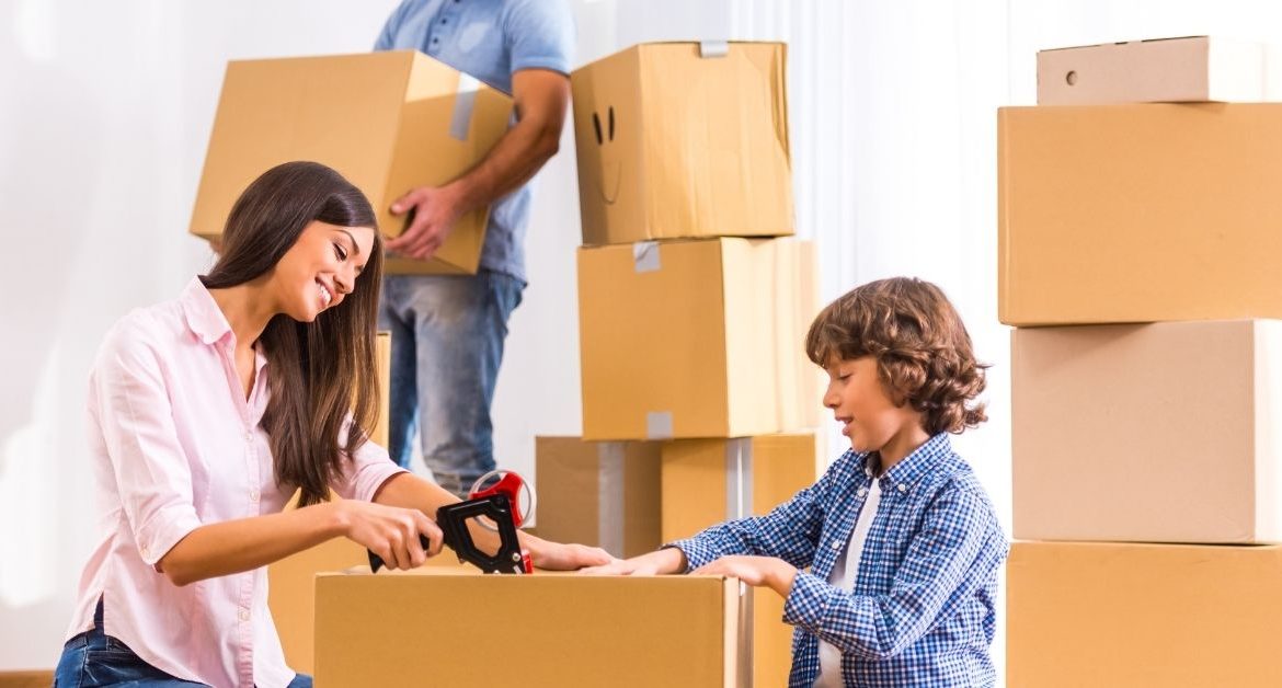 Family packing a home with labeled moving boxes and a moving checklist before relocation