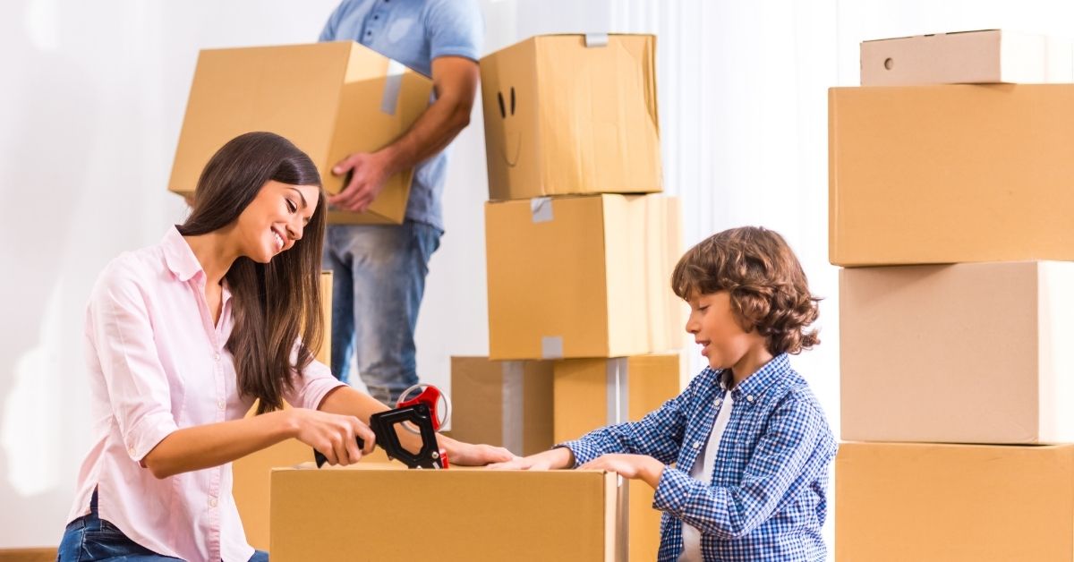 Family packing a home with labeled moving boxes and a moving checklist before relocation