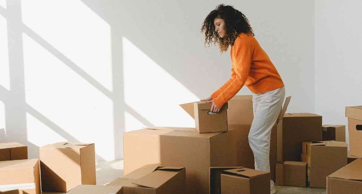 Homeowner organizing labeled moving boxes and following a packing checklist before moving day