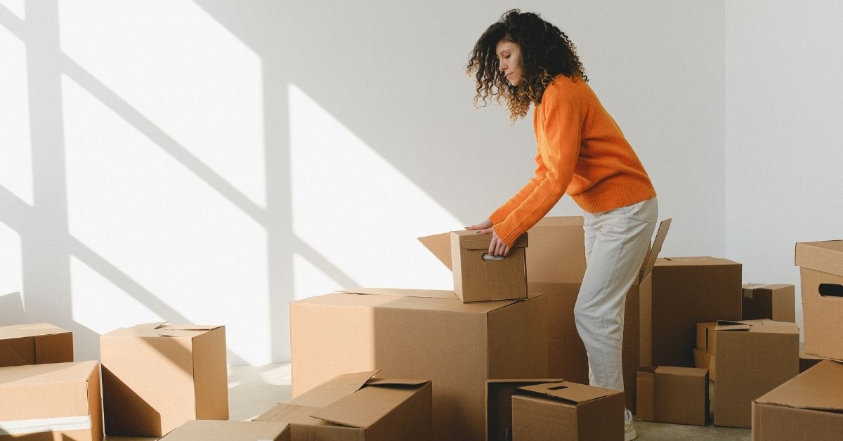 Homeowner organizing labeled moving boxes and following a packing checklist before moving day