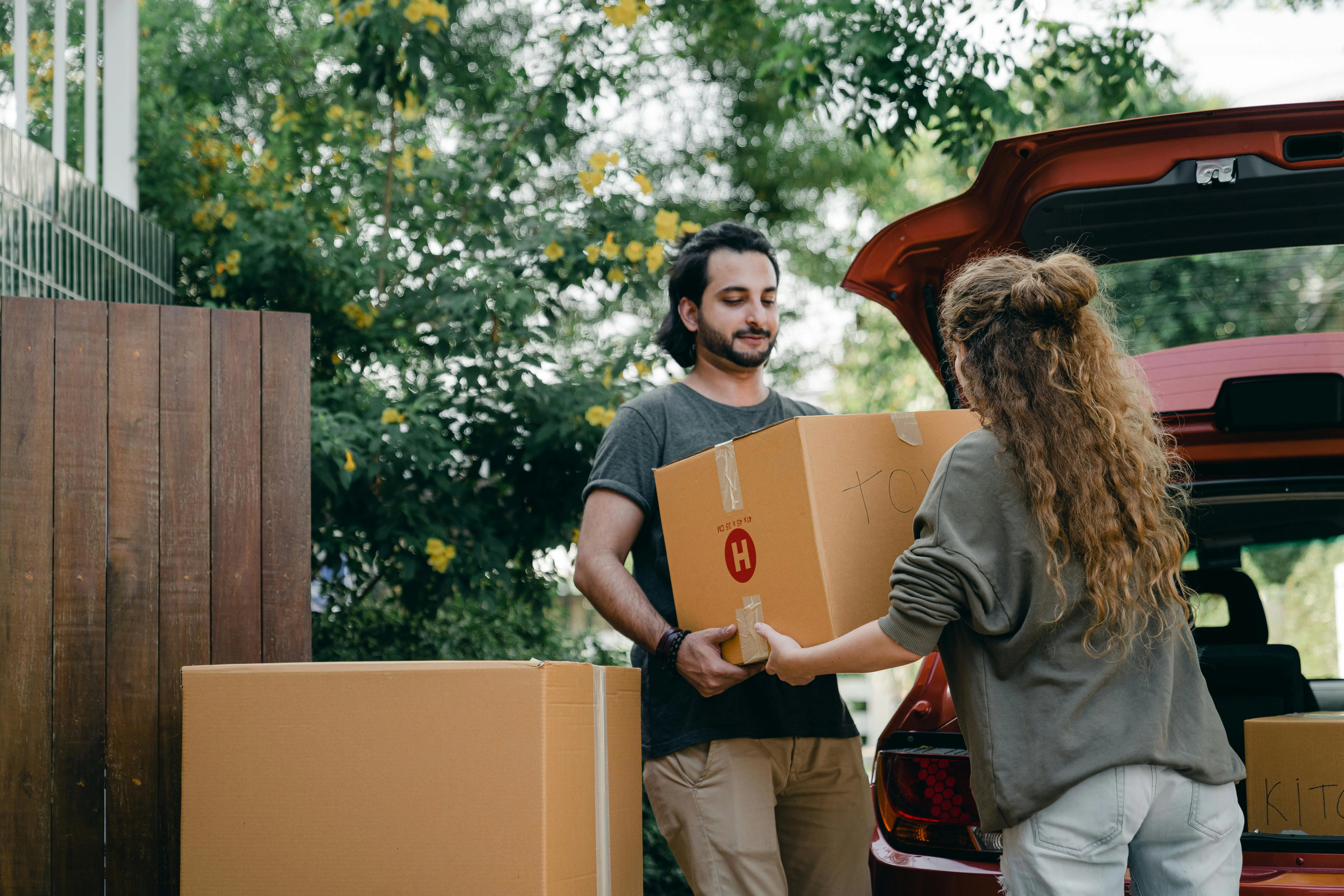 Satisfied customers standing beside a moving truck after a successful and stress-free move with professional packing assistance.