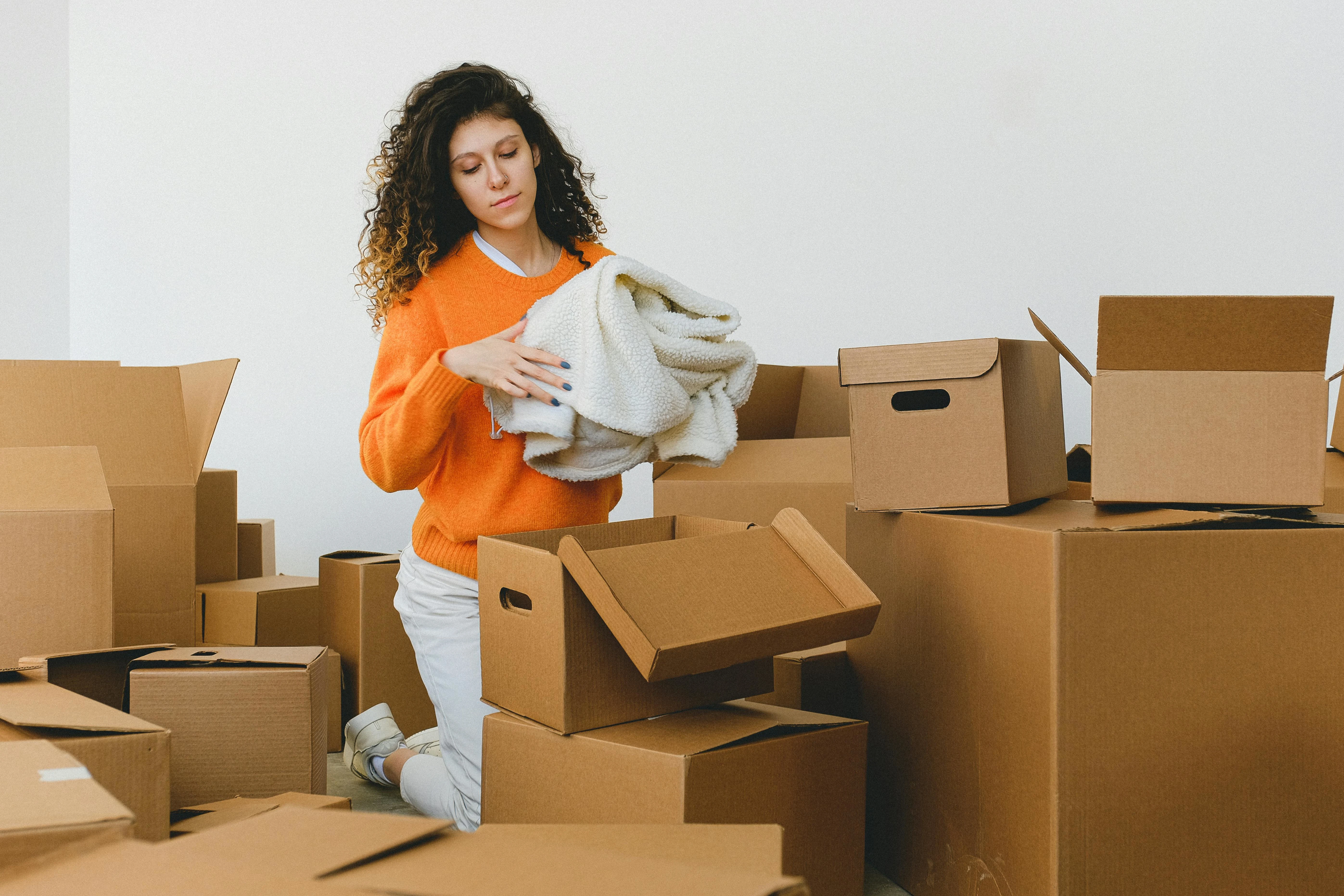 Family packing moving boxes with the help of professional movers for a safe and stress-free relocation.