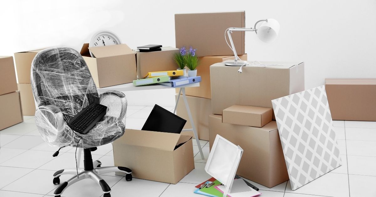 Professional commercial movers handling office furniture and equipment during a business relocation